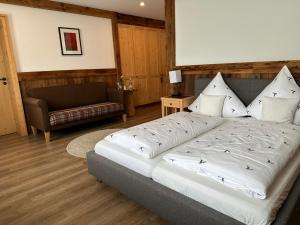 巴特莱辛哈尔Hotel Restaurant Neu Meran的一间卧室配有一张大床和一张沙发