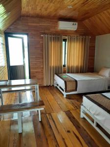 Bố TrạchPOMELO HOMESTAY Phong Nha的一间卧室设有两张床,铺有木地板