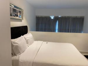 阿克拉Splendid Apartments - Embassy Gardens的卧室配有白色的床和窗户