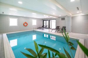 南希Nemea Appart Hotel Home Suite Nancy Centre的一个带椅子的大型游泳池