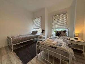 克劳利Charming 2BR Cottage - Fully Furnished - 10min LGW - Free Parking的一间卧室设有一张床和两个窗户。