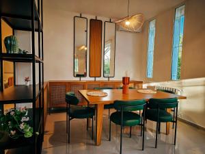 Aḑ ḐahrBeit Mema的一间带木桌和绿色椅子的用餐室
