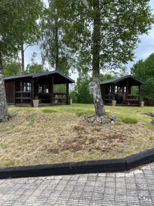 OsbySvensson's Log Cabins的公园里两个有树的亭子