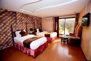 拉合尔Premier inn Mall Lahore的酒店客房设有两张床和电视。