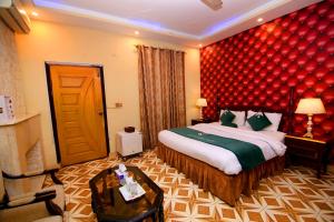 拉合尔Premier inn Mall Lahore的酒店客房,设有床铺和红色的墙壁