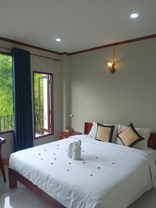 万荣Dokchampa Hotel的卧室设有一张白色大床和一扇窗户。