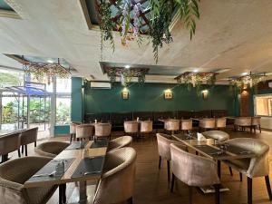 金沙萨Hotel Belle Vie的一间带桌椅和绿色墙壁的餐厅