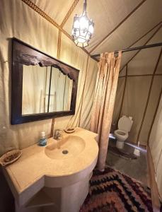 梅尔祖卡Merzouga Desert Awaite camp的一间带水槽、镜子和卫生间的浴室