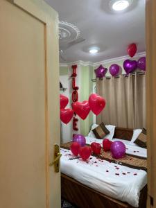 斯利那加Heritage Rose Inn的床上有红色和紫色气球的房间
