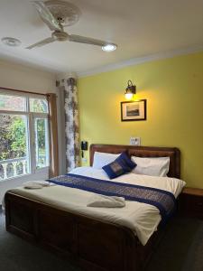 斯利那加Heritage Rose Inn的一间卧室配有一张大床和吊扇