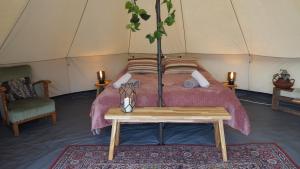 Nederweert-EindBell Tent in een Voedselbos的帐篷内一间卧室,配有一张床