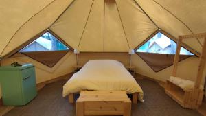 圣安东尼奥·德·卡隆Camping Pla de la Torre的帐篷内的一张床位,设有两个窗户