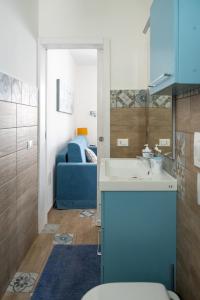 新福卡Seasons Home San Foca的一间带水槽、卫生间和沙发的浴室