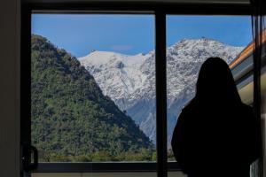 弗朗兹约瑟夫弗朗茨约瑟夫冰川汽车旅馆的一位女士,她从窗外望向山间