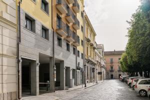 卡塞塔Hotel dei Cavalieri Caserta - La Reggia的一条空的街道,汽车停在大楼的一侧