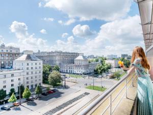 华沙华沙老城宜必思酒店的站在一个眺望城市的阳台上的女人