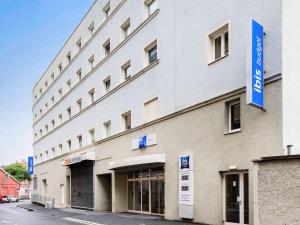 格拉茨格拉茨城宜必思快捷酒店的一座白色的大建筑,上面有蓝色的标志