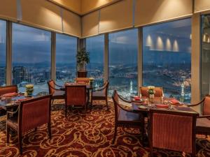 麦加麦加皇家钟楼费尔蒙酒店的一间带桌椅的用餐室和大窗户