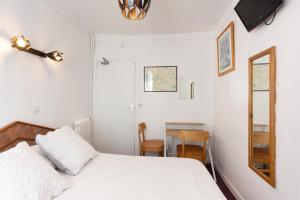 巴黎理想酒店的一间卧室配有一张床、镜子和一张桌子