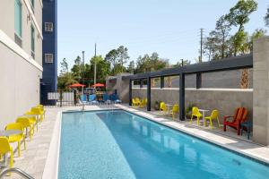 尼斯维尔Home2 Suites By Hilton Niceville Eglin Air Force Base的一座游泳池旁设有黄色椅子