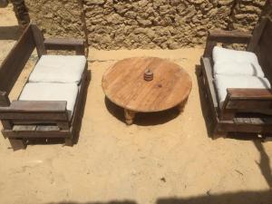 锡瓦Tanirt ecolodge的一张木桌、两把椅子、一张桌子和一张沙发