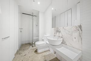 墨尔本Flinders Street Apartments的白色的浴室设有卫生间和水槽。