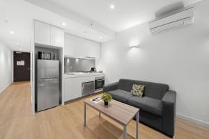 墨尔本Flinders Street Apartments的客厅配有沙发和桌子