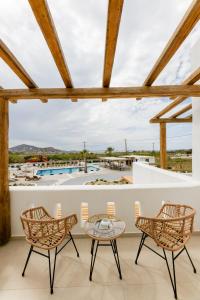 纳克索乔拉Naxos Finest Hotel & Villas的一个带桌椅的庭院和一个游泳池