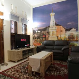 TimuranINEZ Homestay Prawirotaman Yogya的客厅配有电视、沙发和桌子