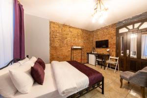 伊斯坦布尔The Frame Hotel & Suites的一间卧室设有一张床和砖墙