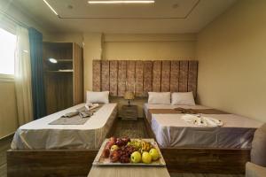 开罗New Gardenia Pyramids view的配有两张床和水果盘的酒店客房