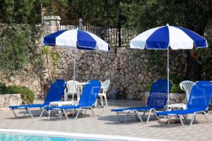 巴尔巴蒂Crystal Blue Hotel by Konnect, Barbati的一组椅子和遮阳伞,位于游泳池旁