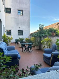 莫加多鲁Hotel Trindade Coelho的一座配有蓝色椅子和桌子的庭院以及一座建筑