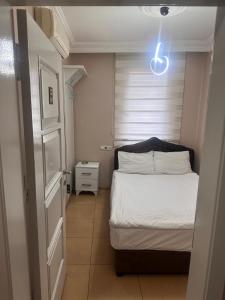 科尼亚阿斯亚酒店的一间小卧室,配有一张床和一个光线