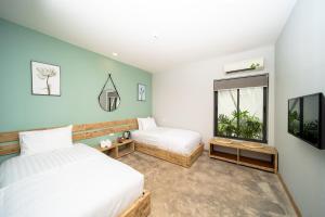 富国9Station Hostel & Bar Phu Quoc的一间卧室设有两张床和窗户。