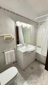 莫加多鲁Hotel Trindade Coelho的一间带水槽、卫生间和镜子的浴室