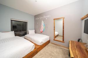 富国9Station Hostel & Bar Phu Quoc的一间卧室配有两张床和镜子