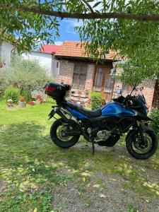 阿尔杰什河畔库尔泰亚Old Court的停在房子前面的一辆蓝色摩托车