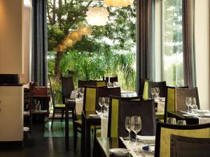 波尔蒂芒木星阿尔加维酒店的餐厅设有桌椅和大窗户。