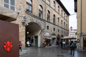 佛罗伦萨Arch Apartment Duomo - Florence的一条有拱门的街道,在一座建筑里,人们在四处走动