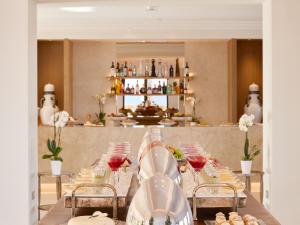 苏尼翁Cape Sounio Grecotel Boutique Resort的一张长桌,上面有红葡萄酒杯