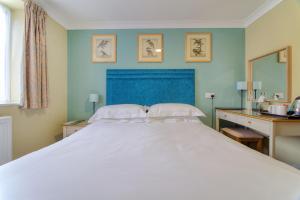 芬当The Bridge House; BW Signature Collection的一间卧室配有一张白色大床和蓝色床头板