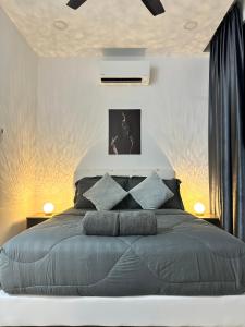 宾南邦ITCC Manhattan Suites by AURORA的一间卧室配有一张带蓝色枕头的大床