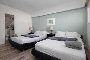 好莱坞Pousada suites的带三张床和浴室的客房