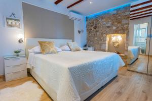 特罗吉尔Apartments & Rooms Trogir Stars FREE PARKING的一间卧室设有一张大床和石墙