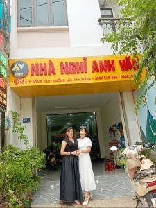 同文NHÀ NGHỈ ANH VĂN的两名妇女站在一座建筑物前面