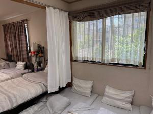 神户Private Inn Bambee的一间卧室设有两张床和大窗户