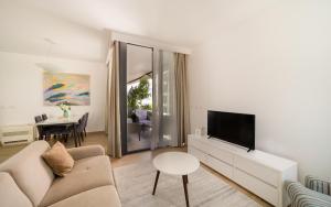 布德瓦Amare Luxury Apartments的带沙发、电视和桌子的客厅
