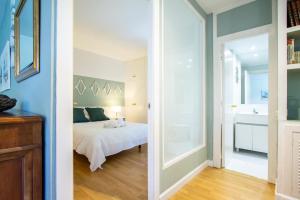 马德里托斯卡德科公寓的一间带白色床的卧室和一间浴室