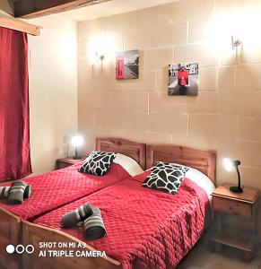 加拉3 bedrooms villa with sea view private pool and enclosed garden at Iz Zebbug的一间卧室配有一张红色棉被的床